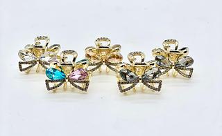 Presilha dourada formato laço cristal (dúzia)